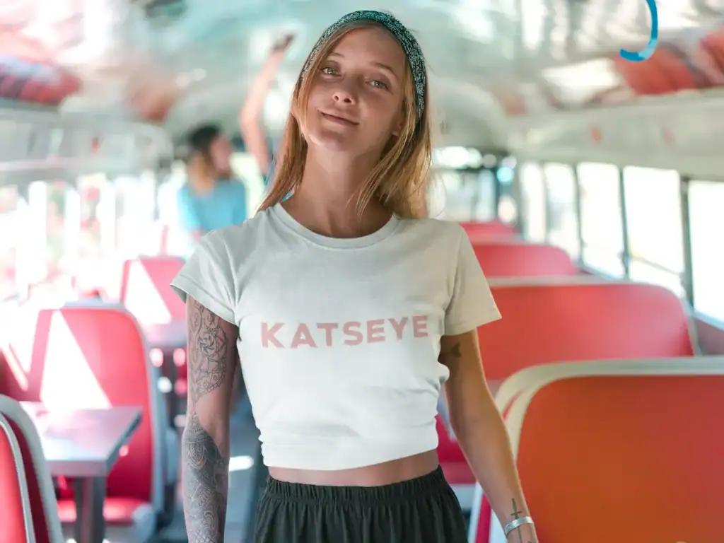 beautiful model wearing white katseye t-shirt while smiling on a bus